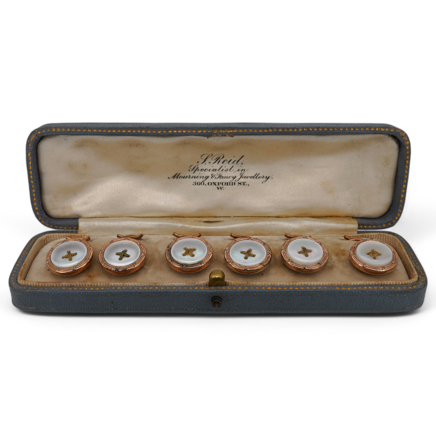 A cased early 20th century gilt metal and mother of pearl set six piece dress stud set. Condition - fair to good